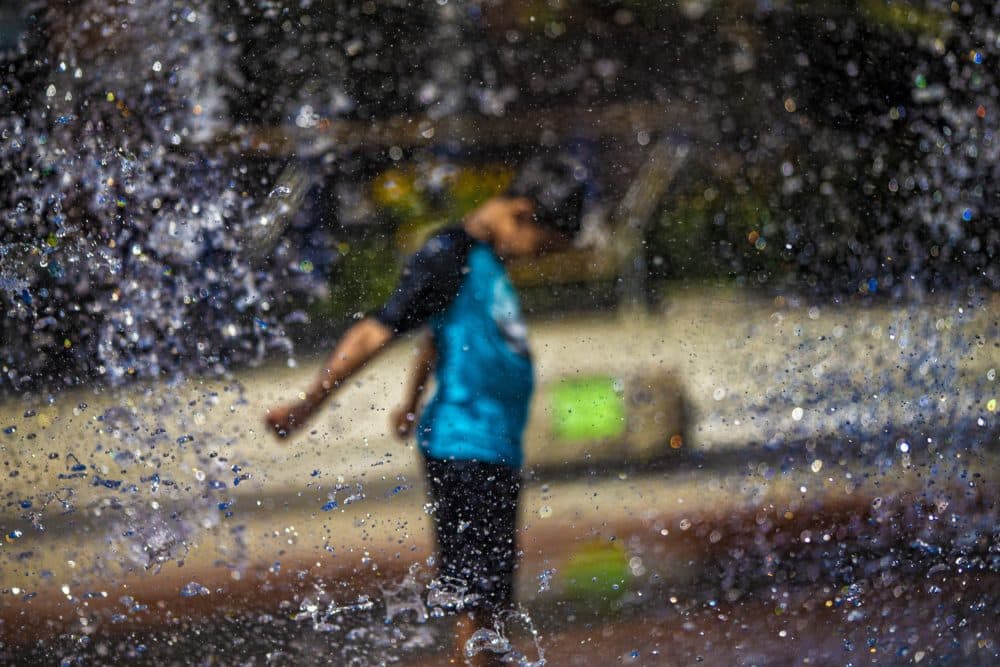 A boy cools off in a fountain on the Rose Kennedy Greenway in Boston last summer. (Jesse Costa/WBUR)