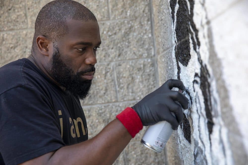 Rob &quot;Problak&quot; Gibbs works on a reference to Rob Stull's art in the &quot;Breathe Life&quot; mural at Madison Park Technical Vocational High School. (Robin Lubbock/WBUR)