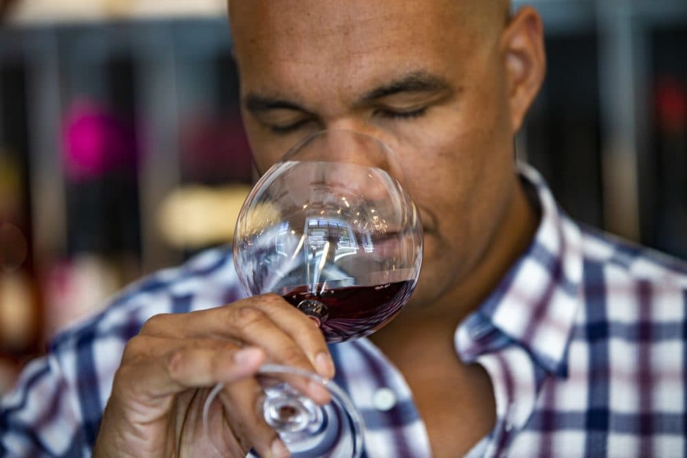 Urban Grape owner TJ Douglas tastes a sample of a J. Bouchon Pais Salvaje at the store. (Jesse Costa/WBUR)