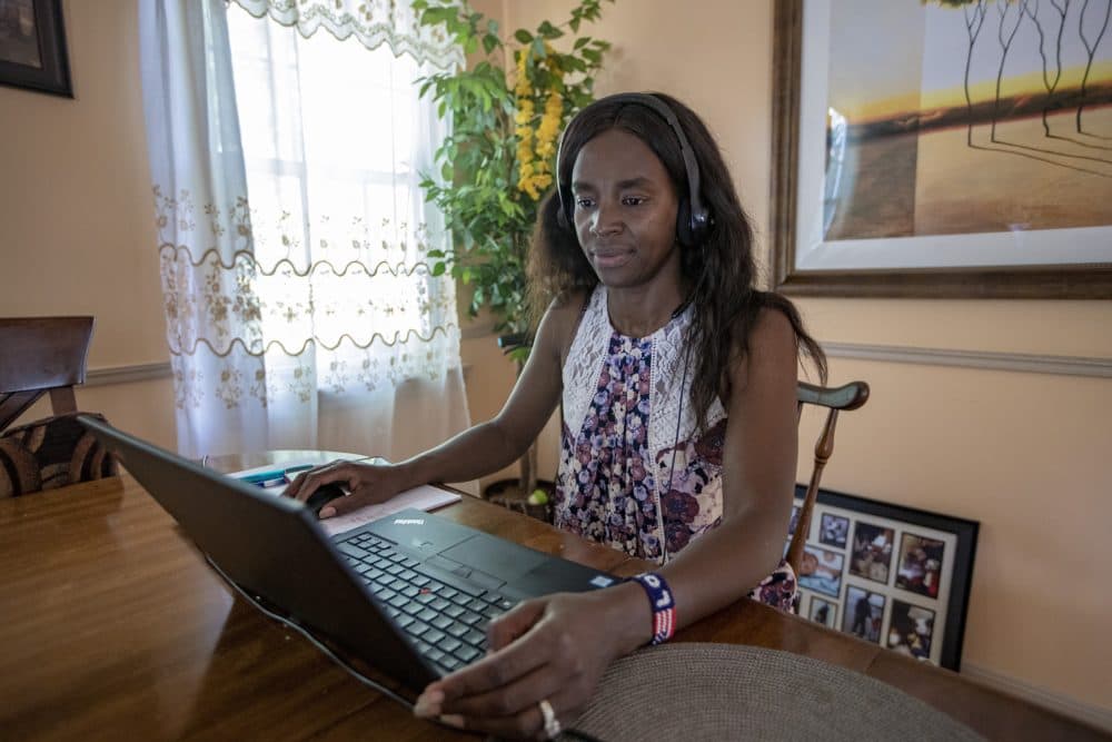 Lorna Kiplagat at work on her laptop at her home. (Jesse Costa/WBUR)