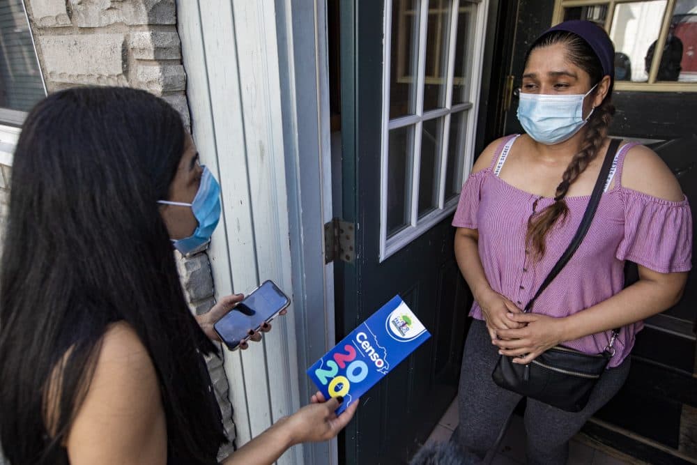 Centro Presente Director Patricia Montes explains to Angelica the importance of filling out the 2020 census as she delivers food to families in need in East Boston. (Jesse Costa/WBUR)