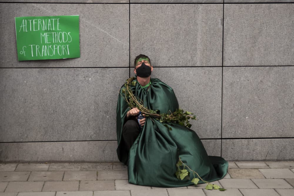 A man, wearing a face mask to protect against the spread of coronavirus, closes his eyes as he has a break during a protest by Extinction Rebellion climate change activists in Brussels, Saturday, June 27, 2020. (Francisco Seco/AP)