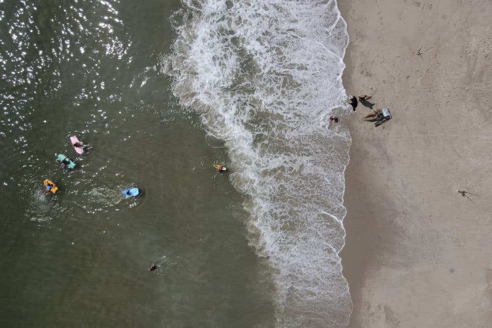 Beachgoers enjoy a hot day along the Atlantic Ocean, Saturday, July 18, 2020, in Rehoboth Beach, Delaware. (Julio Cortez/AP)