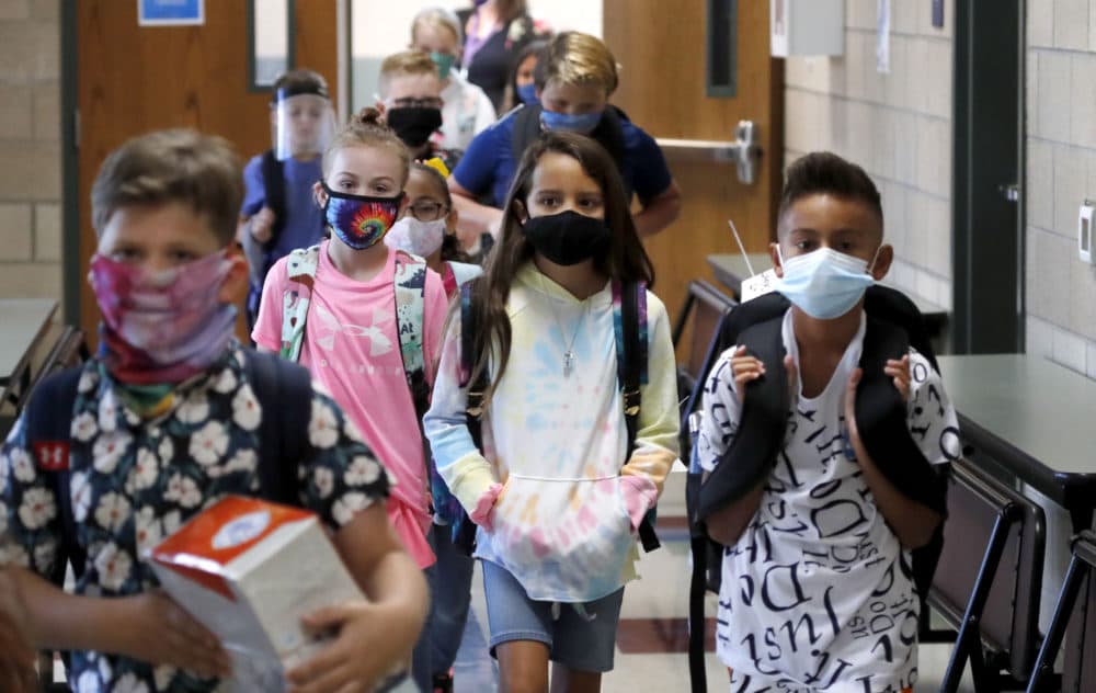 Wearing masks to prevent the spread of COVID19, elementary school students walk to classes to begin their school day in Godley, Texas. (LM Otero/AP)
