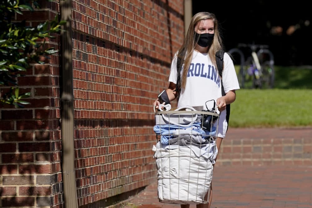 Freshman Sarah Anne Cook carries her blongings as she packs to leave campus following a cluster of COVID-19 cases at the University of North Carolina in Chapel Hill, N.C., Tuesday, Aug. 18, 2020. (Gerry Broome/AP)