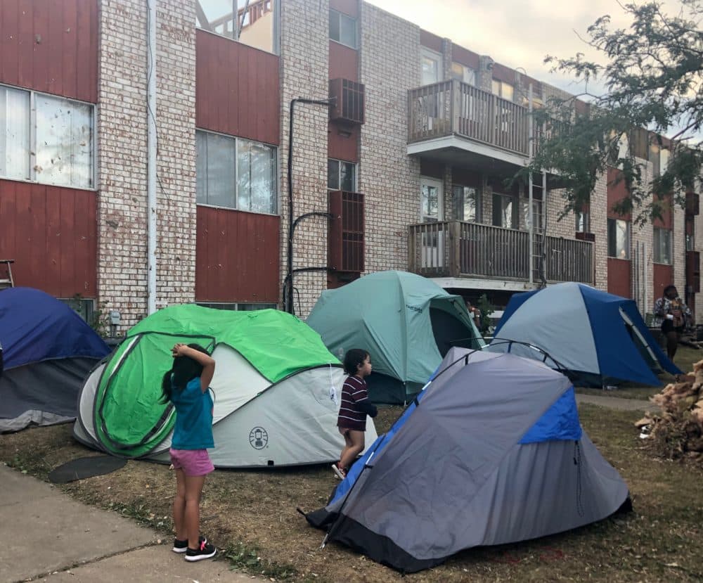 Children standing around the tents. (Kate Payne/Iowa Public Radio)