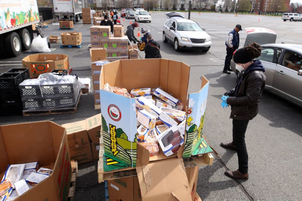 A volunteer prepares to load food into a car at a mobile pantry April 14, 2020 in Detroit, Michigan. The organization distributes food throughout the metro area, which has seen an uptick in demand due to the COVID-19 pandemic. (Gregory Shamus/Getty Images)