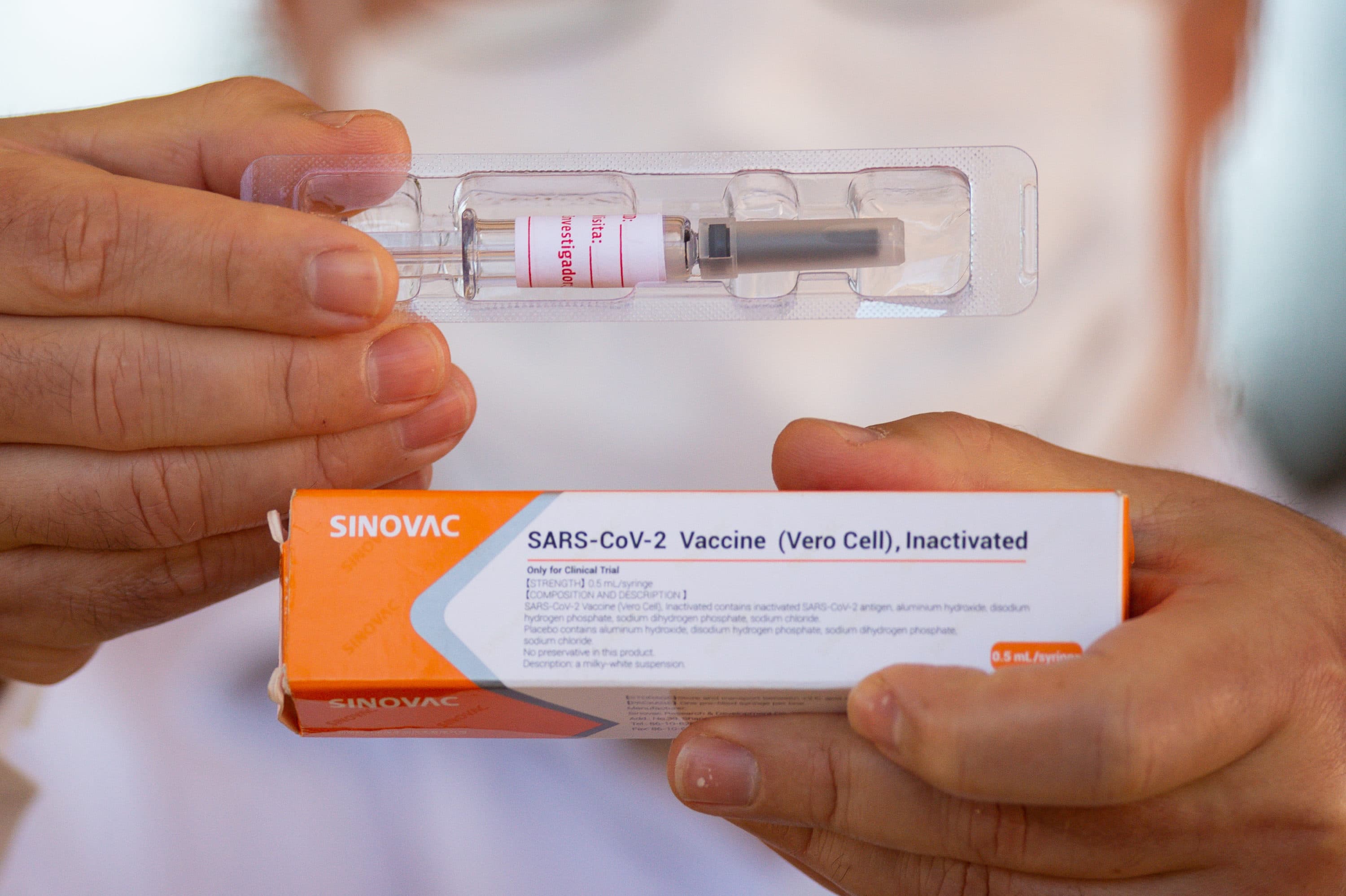 A professor at the University of Brasilia and coordinating doctor for tests of the Sinovac Biotech vaccine, shows the vaccine to journalists amidst the coronavirus pandemic on Aug. 5, 2020 in Brazil. (Andressa Anholete/Getty Images)