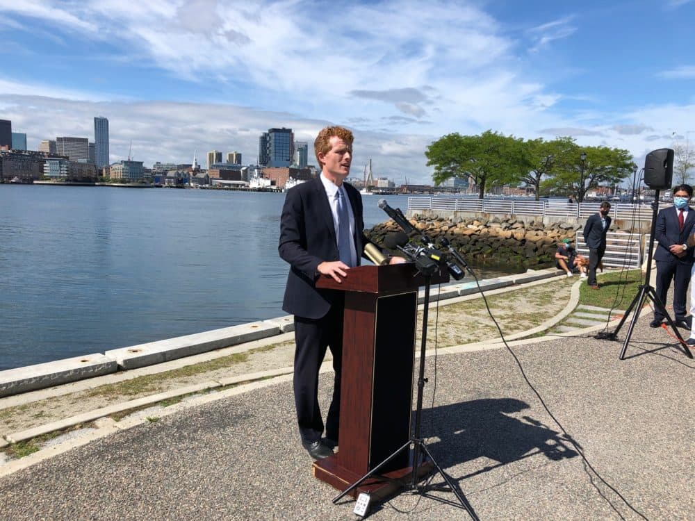 With the Boston skyline as a backdrop, U.S Rep. Joe Kennedy campaigns in LoPresti Park in East Boston (Anthony Brooks/WBUR)