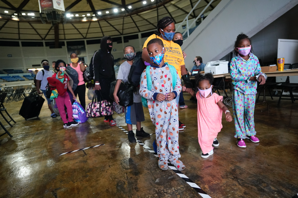 Victoria Nelson with her children Autum Nelson, 2, Shawn Nelson, 7, and Asia Nelson, 6, line up to board a bus to evacuate Lake Charles, La., Wednesday, Aug. 26, 2020, ahead of Hurricane Laura. (Gerald Herbert/AP)