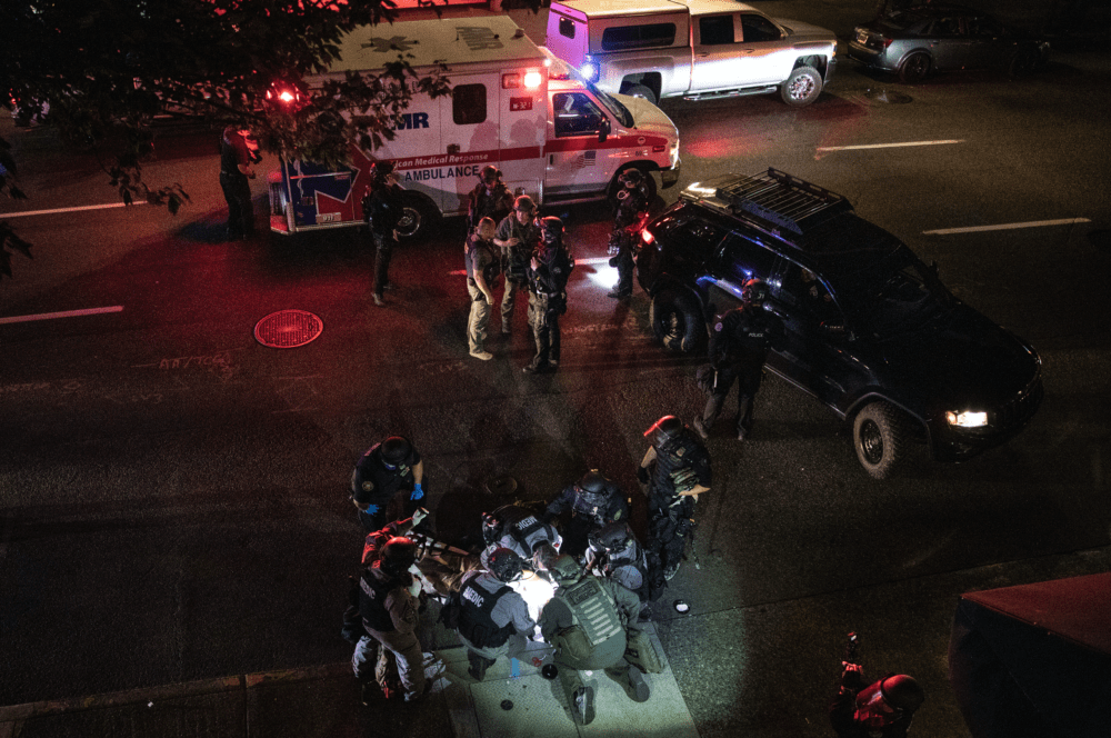A man is treated after being shot Saturday, Aug. 29, 2020, in Portland, Ore. It wasn’t clear if the fatal shooting late Saturday was linked to fights that broke out as a caravan of about 600 vehicles was confronted by counter-demonstrators in the city’s downtown. (Paula Bronstein/AP)