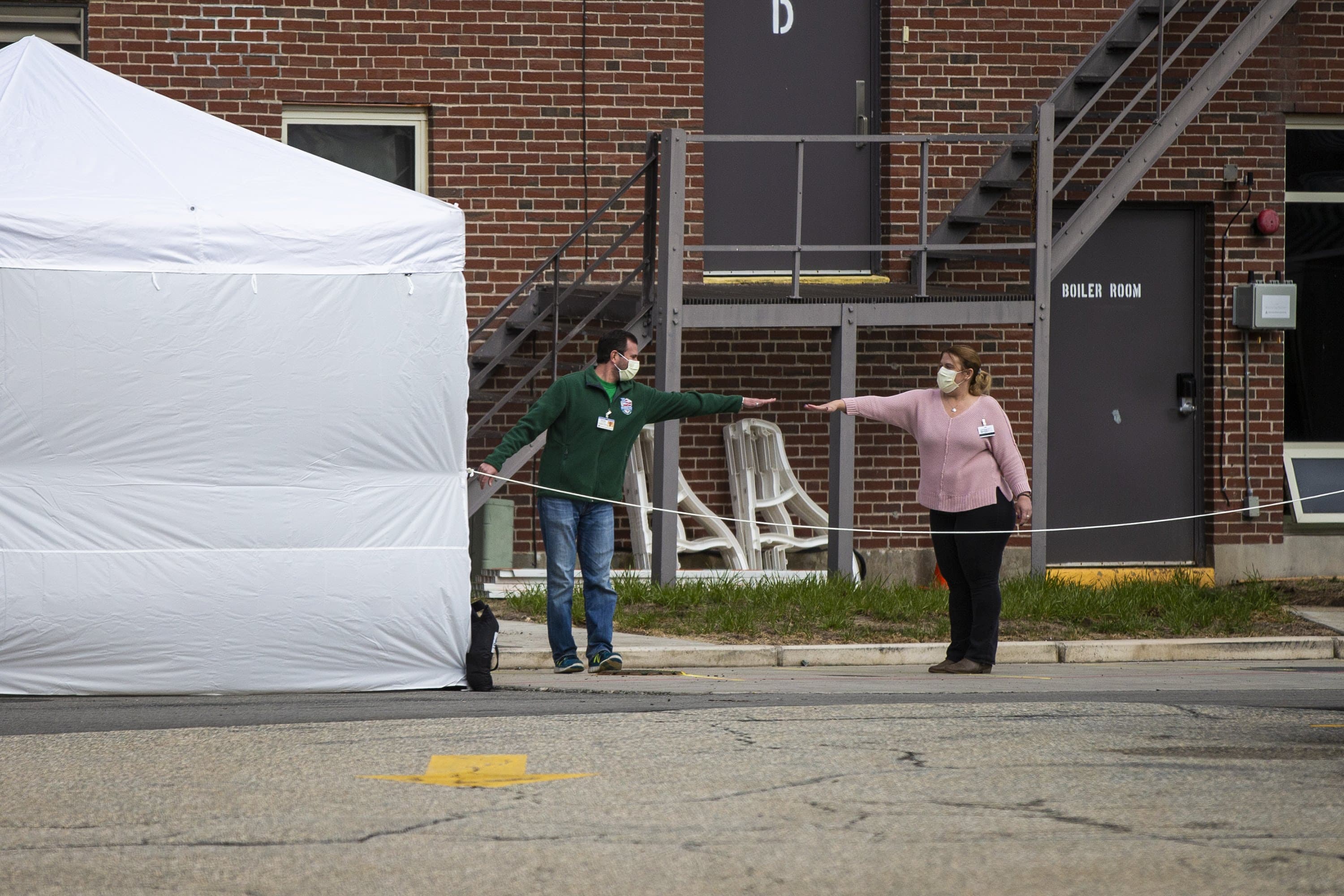 March 31: Two employees of the Soldiers’ Home in Holyoke reach out to one another, but don’t touch, to say goodbye. The state-run long-term residence and health facility became a major outbreak spot and led to firings and resignations among senior leadership. (Jesse Costa/WBUR)