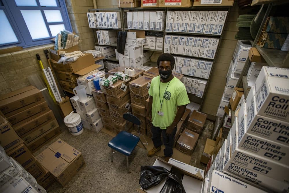 Custodian Earnest Bass stands in the storage room filled with cleaning supplies at the McCormack School in Dorchester. (Jesse Costa/WBUR)