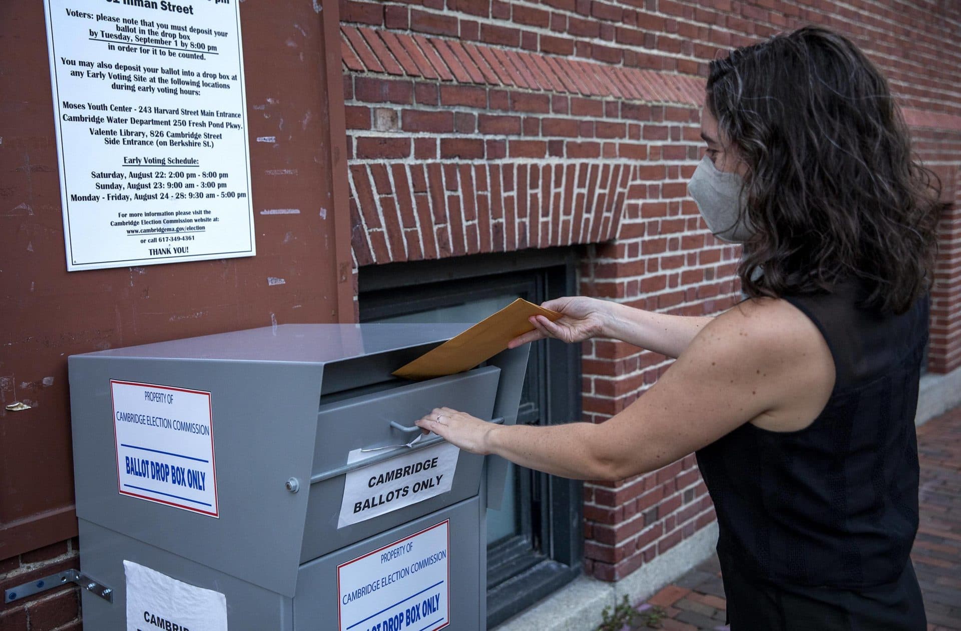 A Massachusetts voter places her vote into the Cambridge ballot dropbox ahead of the state primary. (Robin Lubbock/WBUR)
