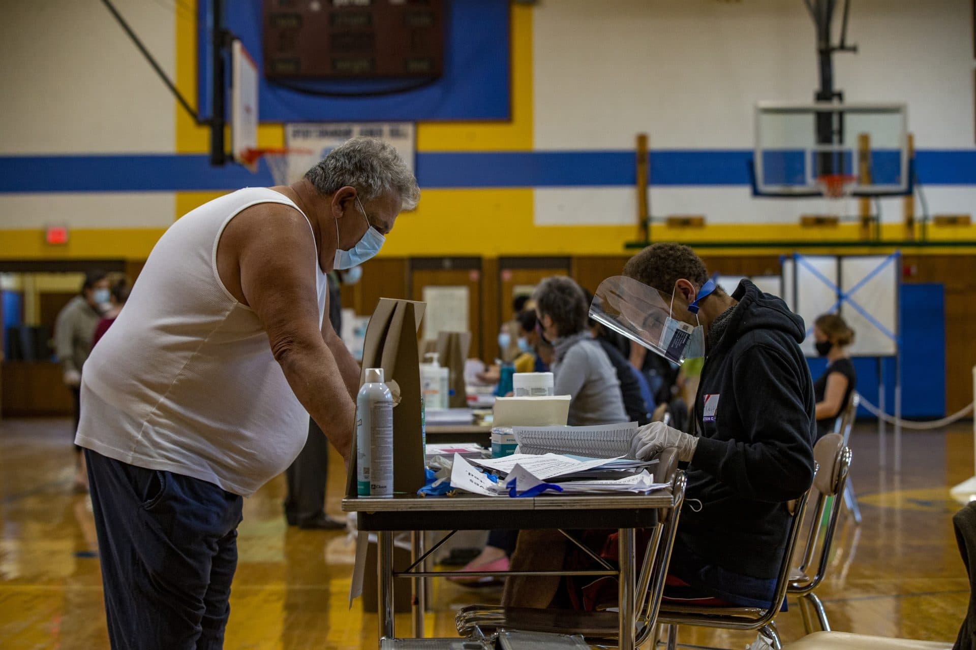 A voter checks in to receive his ballot at the Ward 1 polling station at East Boston High School as election day begins. (Jesse Costa/WBUR)