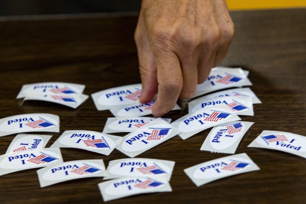 A voter picks up an “I Voted” sticker at Ward 1 in East Boston High School on Election Day of the Massachusetts state primary. (Jesse Costa/WBUR)