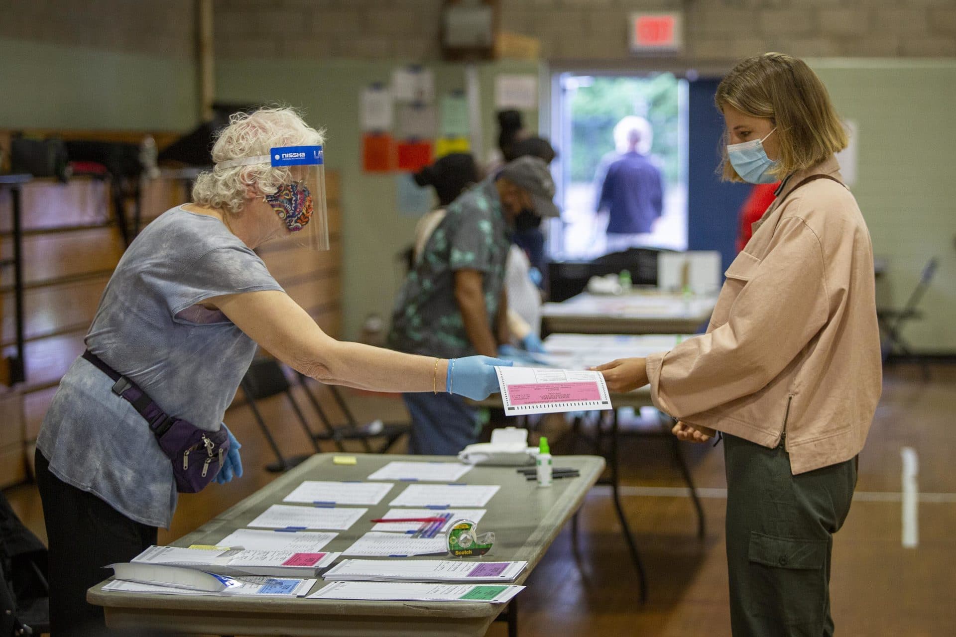 A woman collects her ballot at the polling station on Linnaean St. in Cambridge. (Robin Lubbock/WBUR)