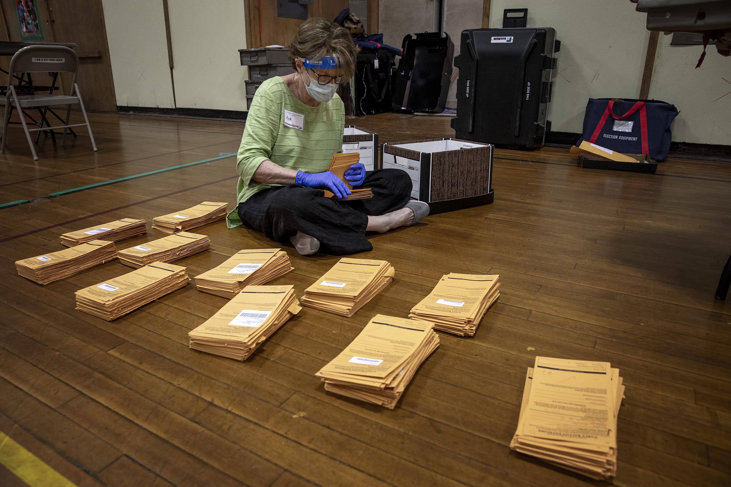 Polling inspector Ann McClenahan counts early voting ballot envelopes at the polling station on Linnaean St. in Cambridge, Mass. (Robin Lubbock/WBUR)
