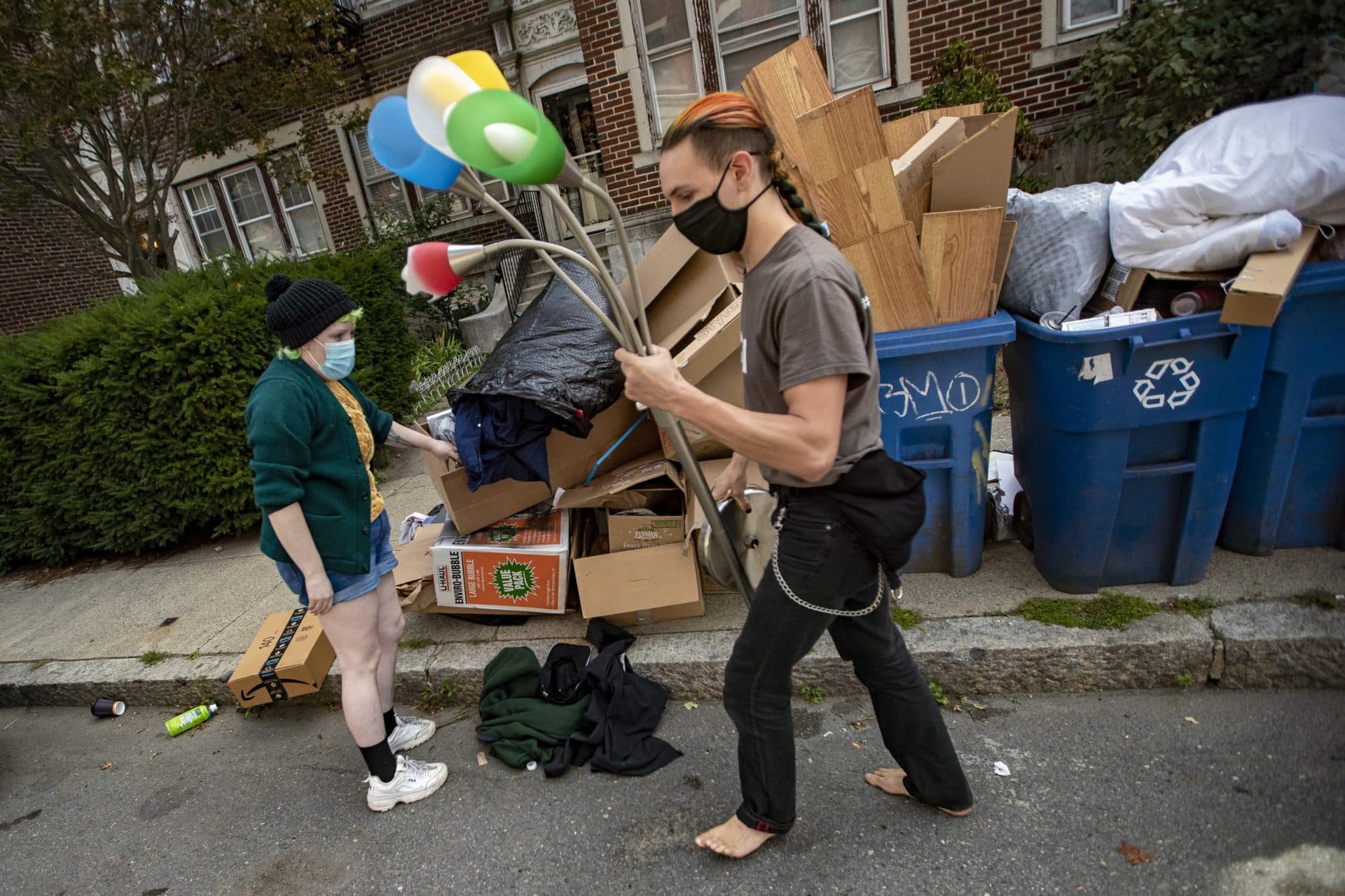 Some treasure hunters find a lamp discarded on the sidewalk on Reedsdale Street in Allston. (Jesse Costa/WBUR)