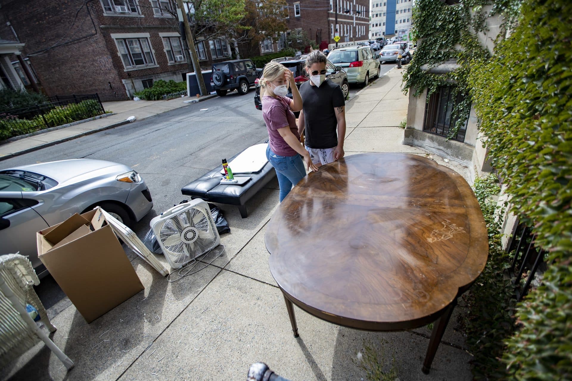Treasure hunters and Berklee students Mina Nystead, left, and Ciaran De Chud scope out a table left out on Reedsdale Street. (Jesse Costa/WBUR)