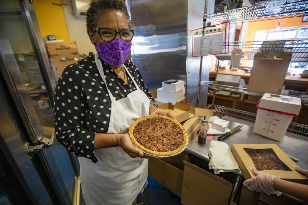 Petsi Pies founder and owner Renee McLeod holds a pecan pie in the kitchen as they are boxed up for sale. (Jesse Costa/WBUR)