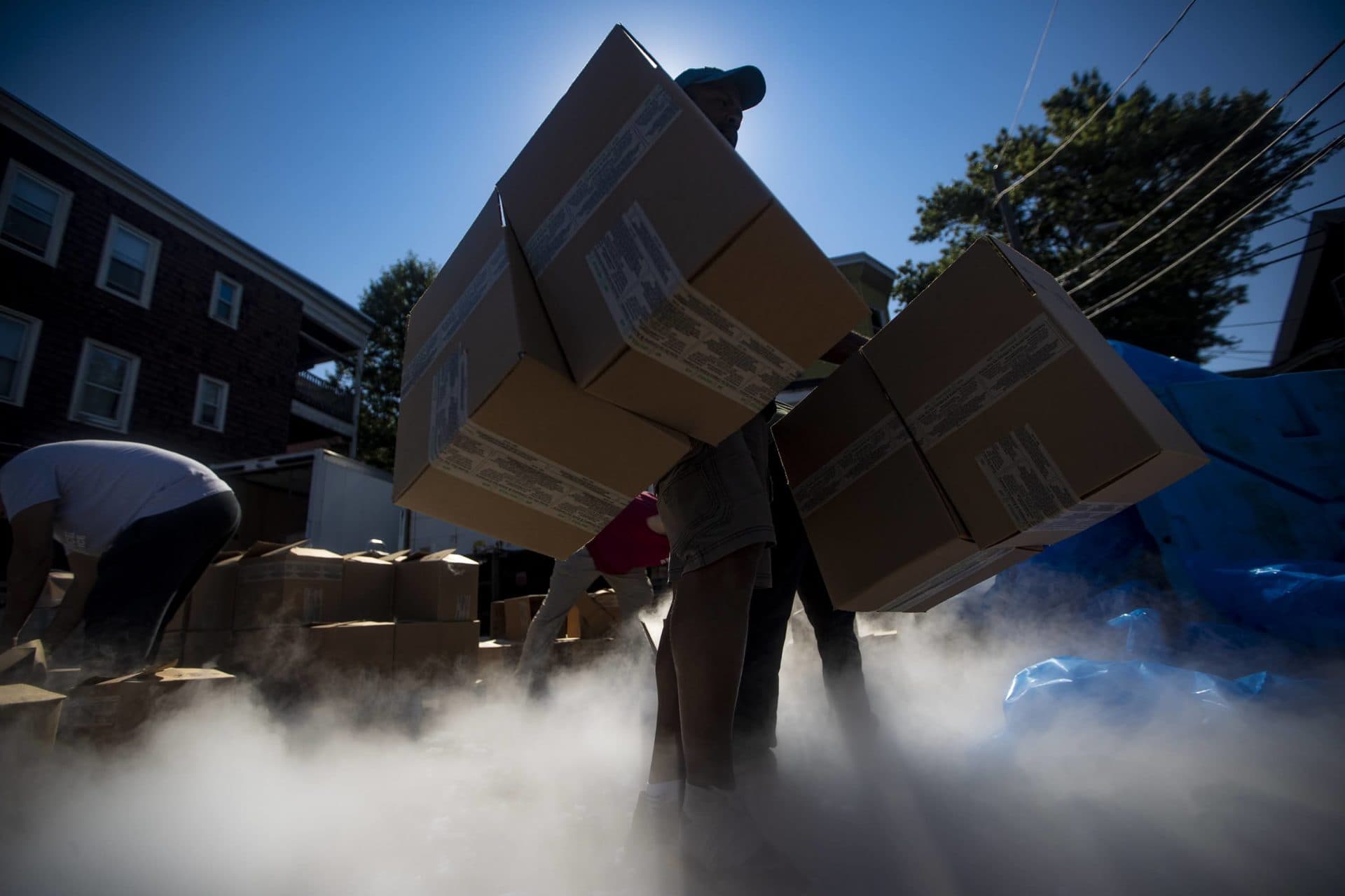 Workers at the Acme Ice Company in Cambridge load 50,000 pounds of dry ice into boxes to be shipped out to various pharmaceutical companies in the area for storing vaccine samples of COVID-19. (Jesse Costa/WBUR)