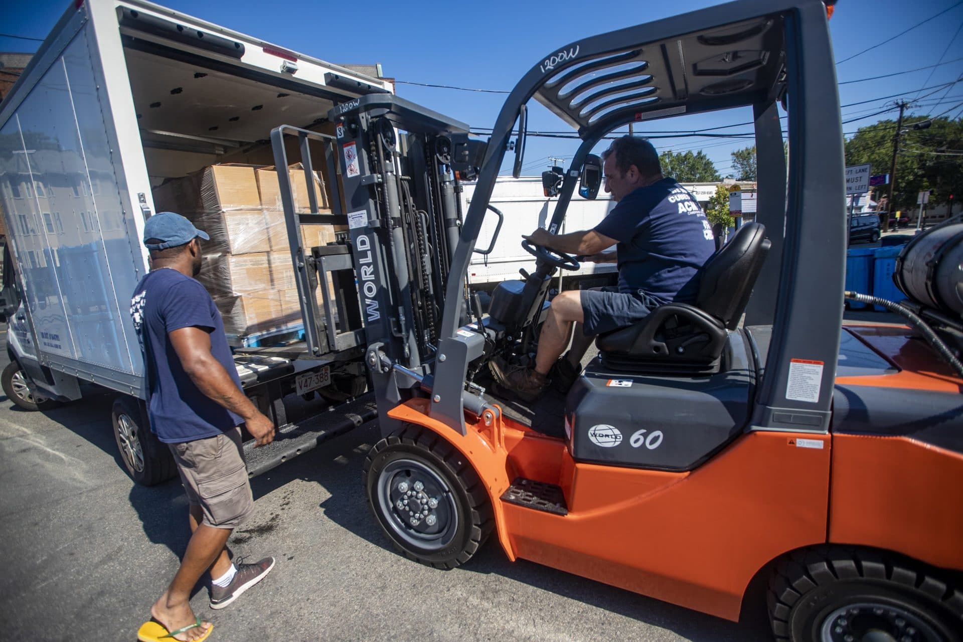 Workers at the Acme Ice Company in Cambridge load 50,000 pounds of dry ice into boxes to be shipped out to various pharmaceutical companies in the area for storing vaccine samples of COVID-19. (Jesse Costa/WBUR)