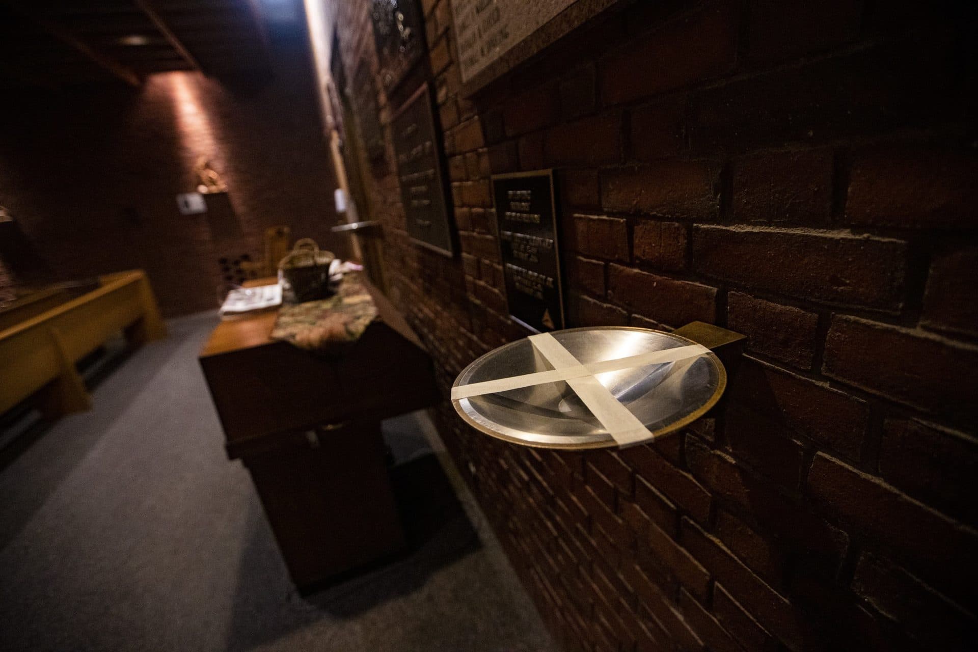 Holy water bowls at the chapel are taped up due to the ongoing coronavirus pandemic. (Jesse Costa/WBUR)