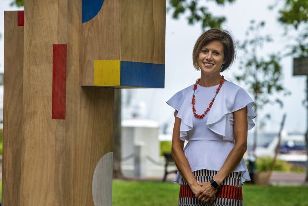 Kate Gilbert, executive director of Now + There, stands next to one of the structures in &quot;The Shape of Play&quot; art installation. (Jesse Costa/WBUR)