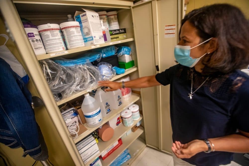 Plymouth Community Intermediate School nurse Judy Duarte looks in a cabinet in the nurse’s office loaded with supplies including personal protective equipment. (Jesse Costa/WBUR)