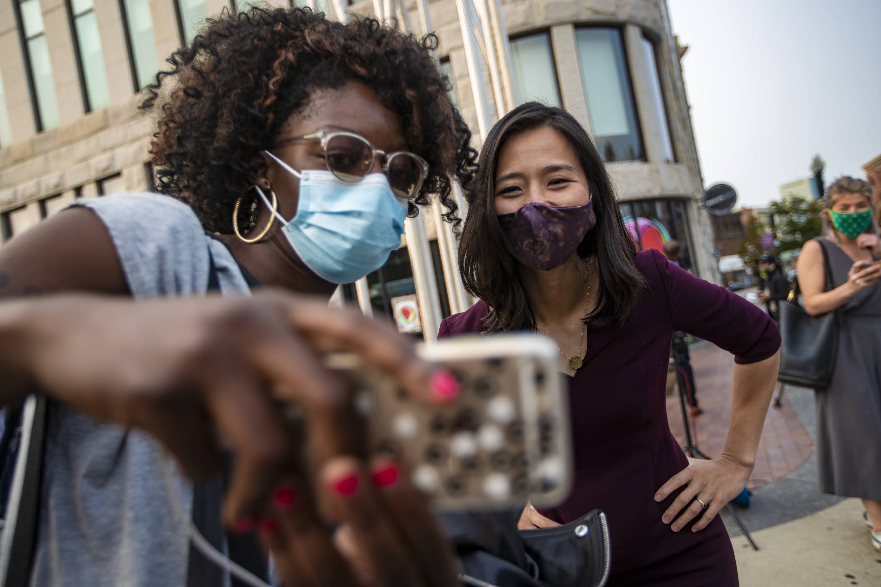 A supporter snaps a selfie with mayoral candidate Michelle Wu during a campaign appearance in Nubian Square. (Jesse Coista/WBUR)