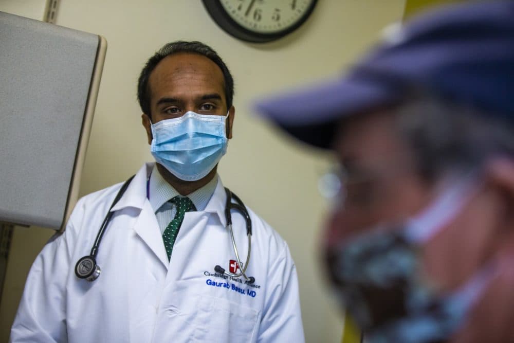 Dr. Gaurab Basu listens to patient Steve Kearns. (Jesse Costa/WBUR)