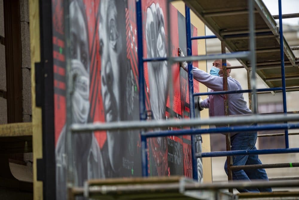 The mural is carefully installed in panels. (Jesse Costa/WBUR)