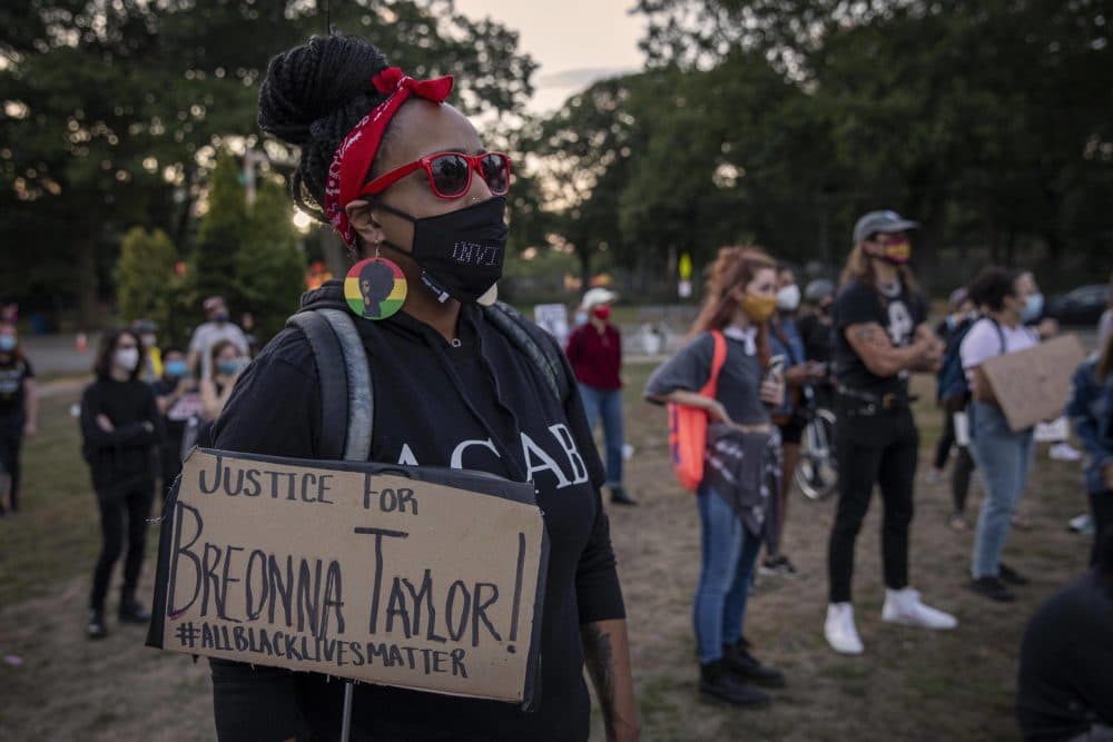 Candice Woodson, from Dorchester, holds a &quot;Justice For Breonna Taylor!&quot; sign at the evening protest in Franklin Park. (Robin Lubbock/WBUR)