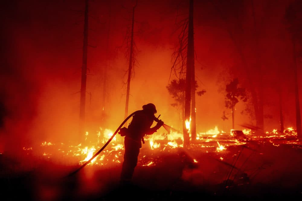 In this Sept. 7, 2020 photo, a firefighter battles the Creek Fire as it threatens homes in the Cascadel Woods neighborhood of Madera County, Calif. (Noah Berger/AP)