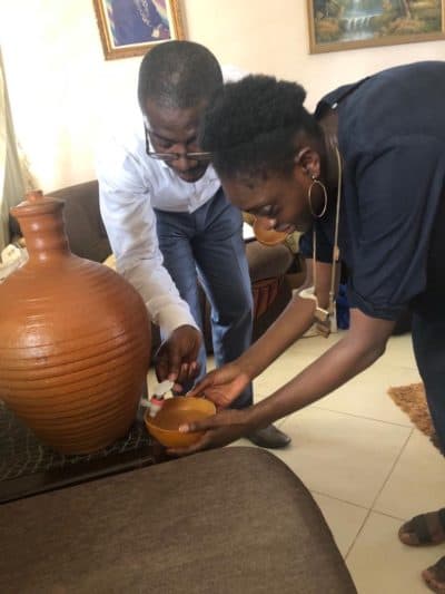 Andrea Nyamekye helps pour water into a calabash, a clay bowl for drinking water, during a visit with family in Ghana. (Courtesy Andrea Nyamekye)