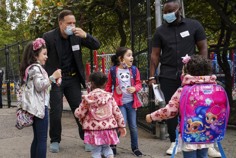 Students greet school staff as they arrive for in-person classes outside Public School 188 The Island School, Tuesday, Sept. 29, 2020, in the Manhattan borough of New York. Hundreds of thousands of elementary school students are heading back to classrooms. (John Minchillo/AP)