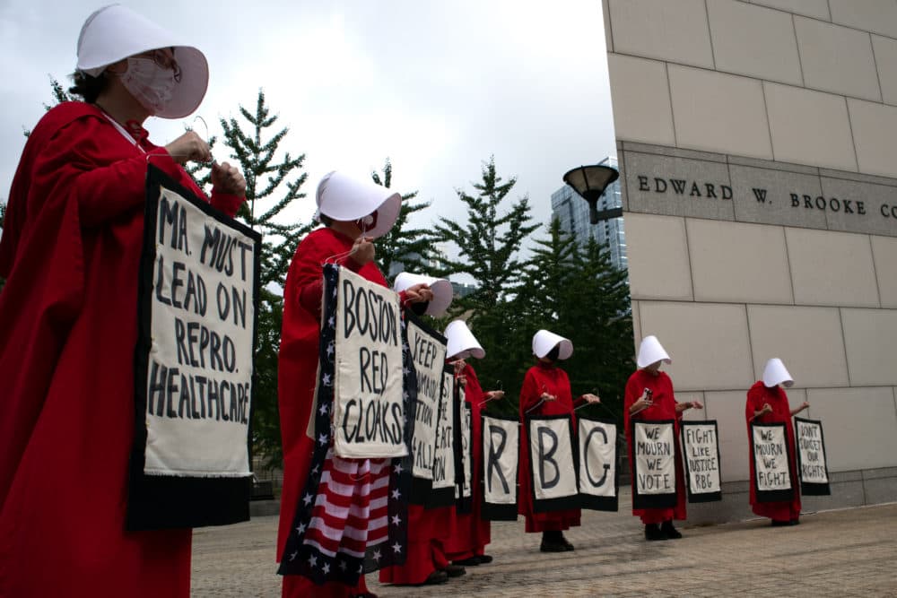 Members of a group called the Boston Red Cloaks gather outside the Edward W. Brooke courthouse in Boston, prior to a news conference in which abortion rights advocates urged state lawmakers to pass statutory protections for abortion. (Adrian Ma/WBUR)