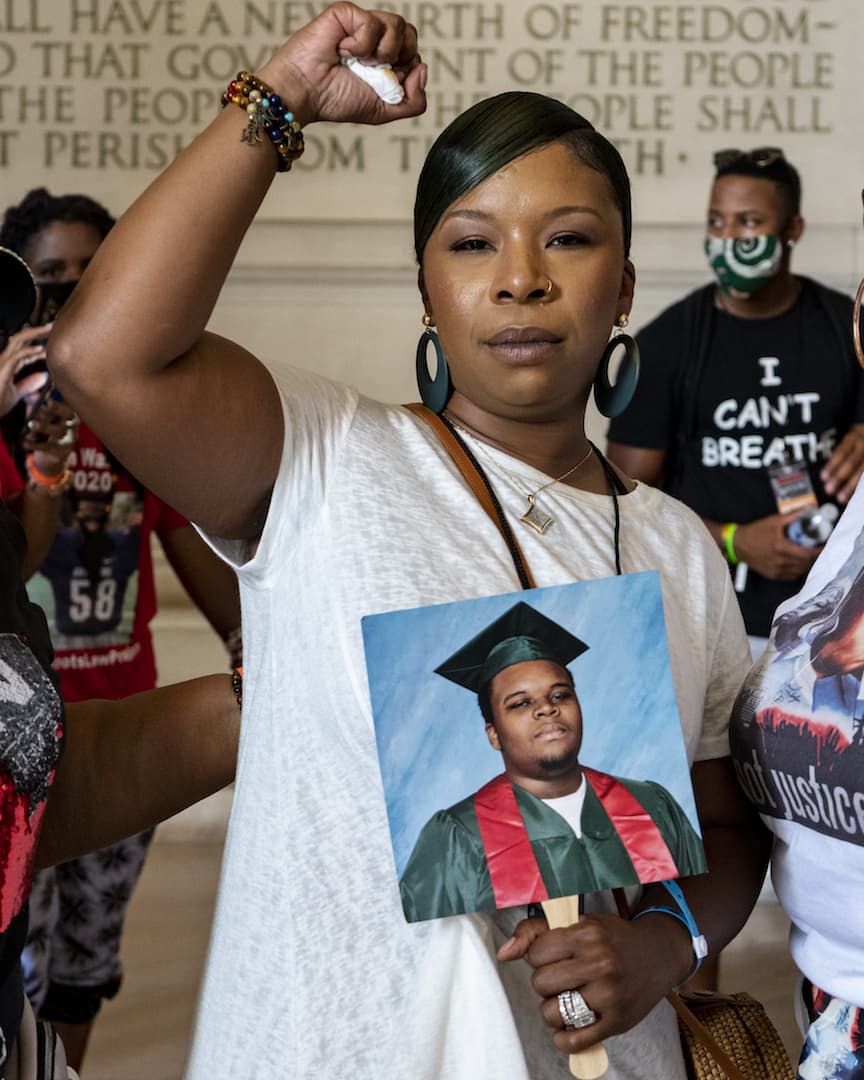 Lesley McSpadden, Michael Brown's mother, stands inside of the Lincoln Memorial with her hand raised in pride and power. (OJ Slaughter for WBUR)