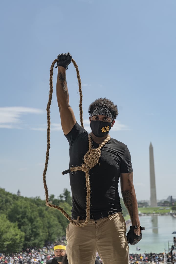A march participant holds a noose around his neck. (OJ Slaughter for WBUR)