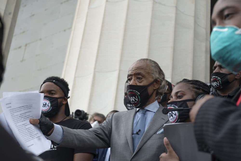 Al Sharpton descends the steps of the Lincoln Memorial with the day's agenda in hand. (OJ Slaughter for WBUR)