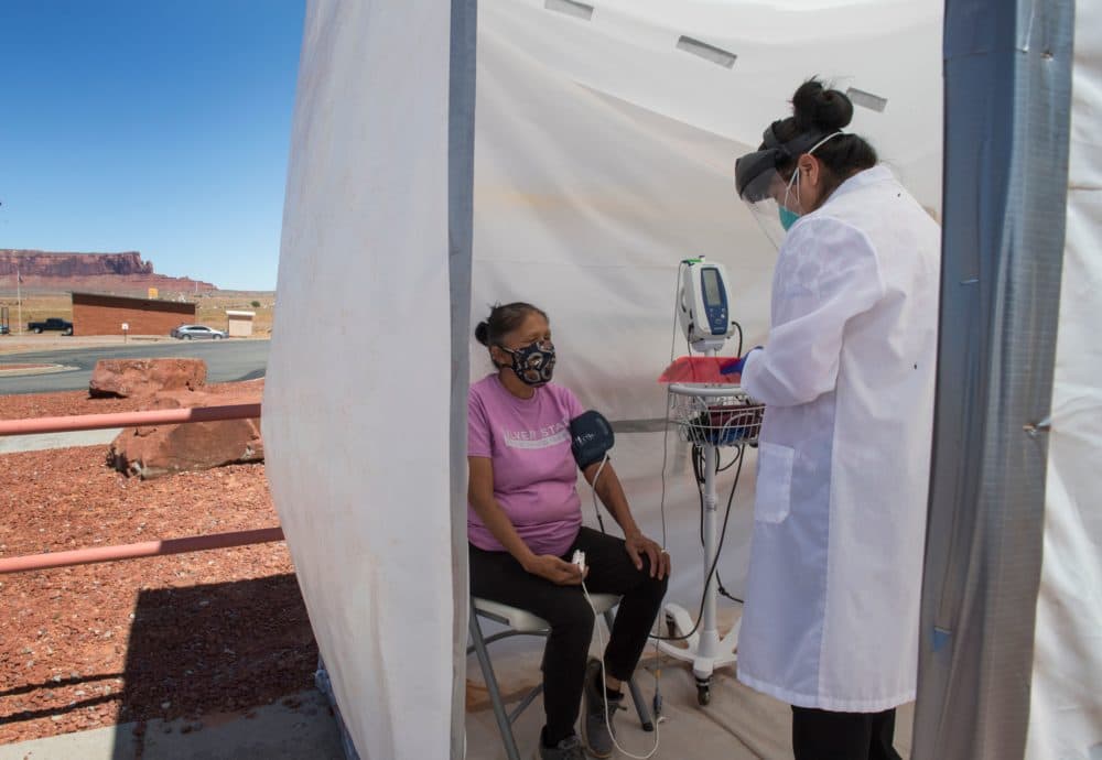 A nurse checks vitals from a Navajo Indian woman complaining of virus symptoms, at a COVID-19 testing center at the Navajo Nation town of Monument Valley in Arizona on May 21, 2020. (MARK RALSTON/AFP via Getty Images)