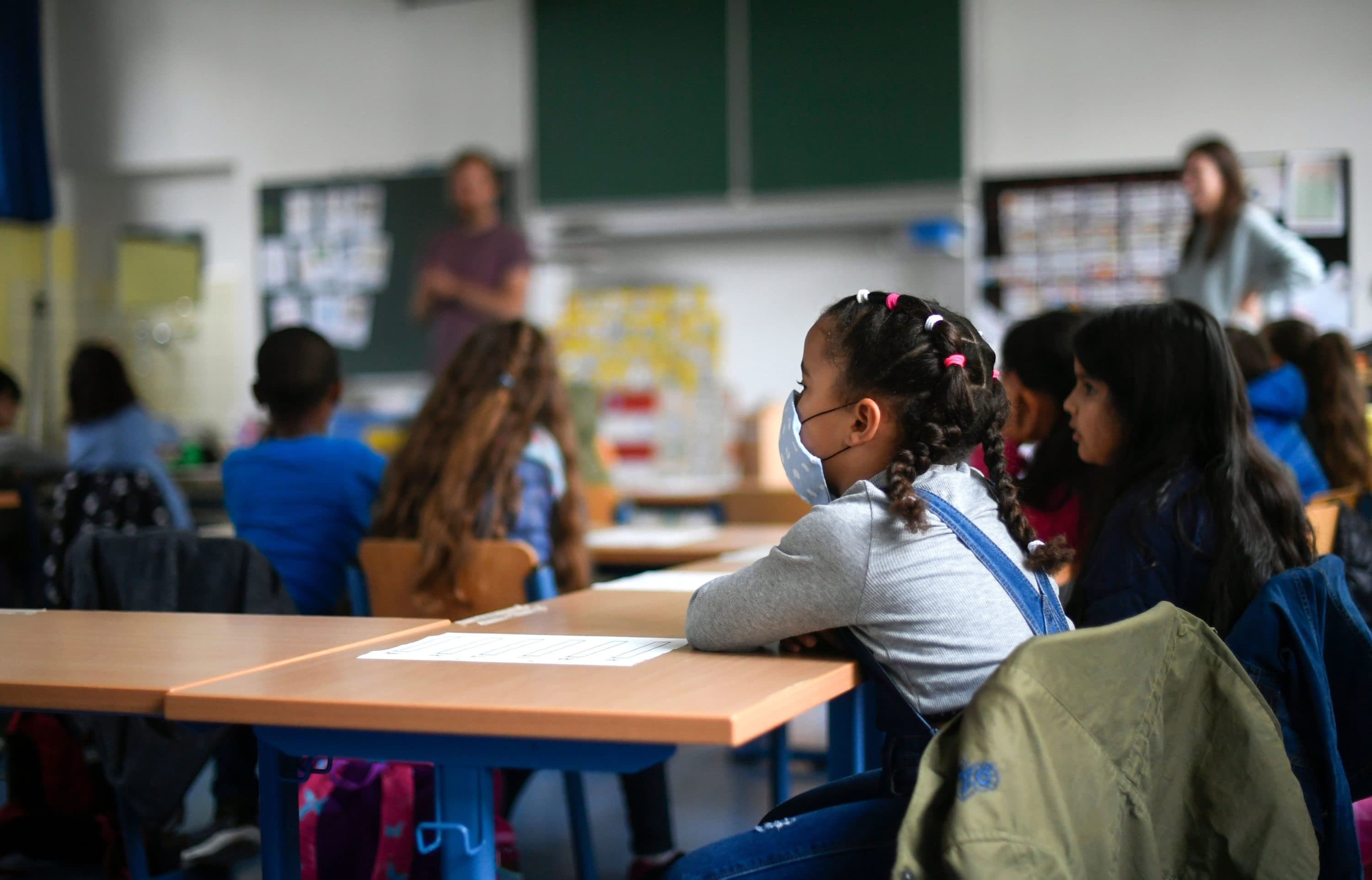 A girl wears a face mask as students sit in a classroom in Germany. (Ina Fassbender/AFP via Getty Images)