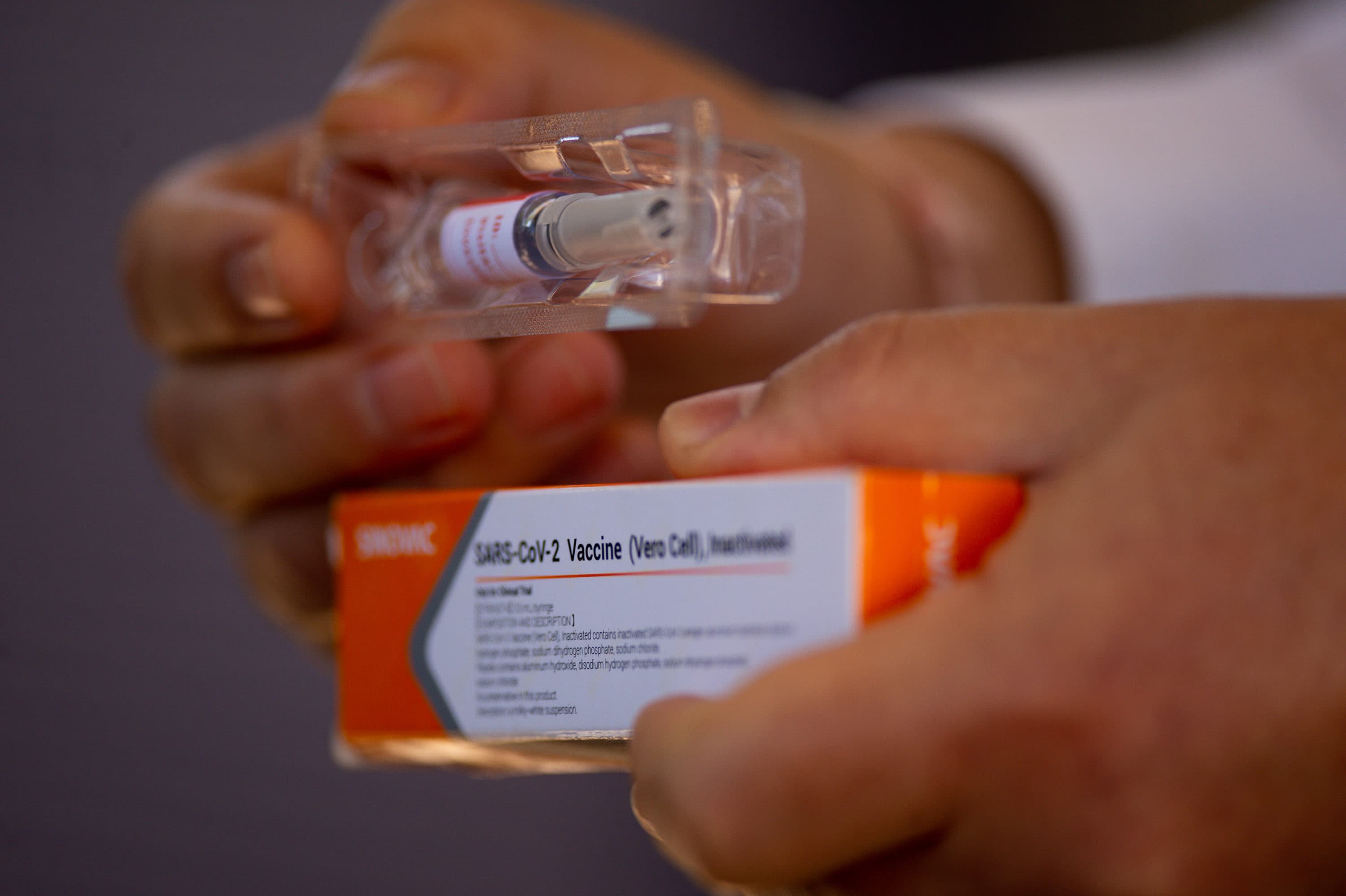 A professor at the University of Brasilia and coordinating doctor for tests of the Sinovac Biotech vaccine, shows the vaccine to journalists at the University Hospital on Aug. 5, 2020. (Andressa Anholete/Getty Images)