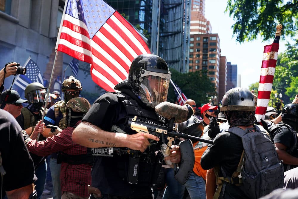 A member of the Proud Boys fires a paint ball gun into a crowd of anti-police protesters as the two sides clashed on August 22, 2020 in Portland, Oregon. (Nathan Howard/Getty Images)