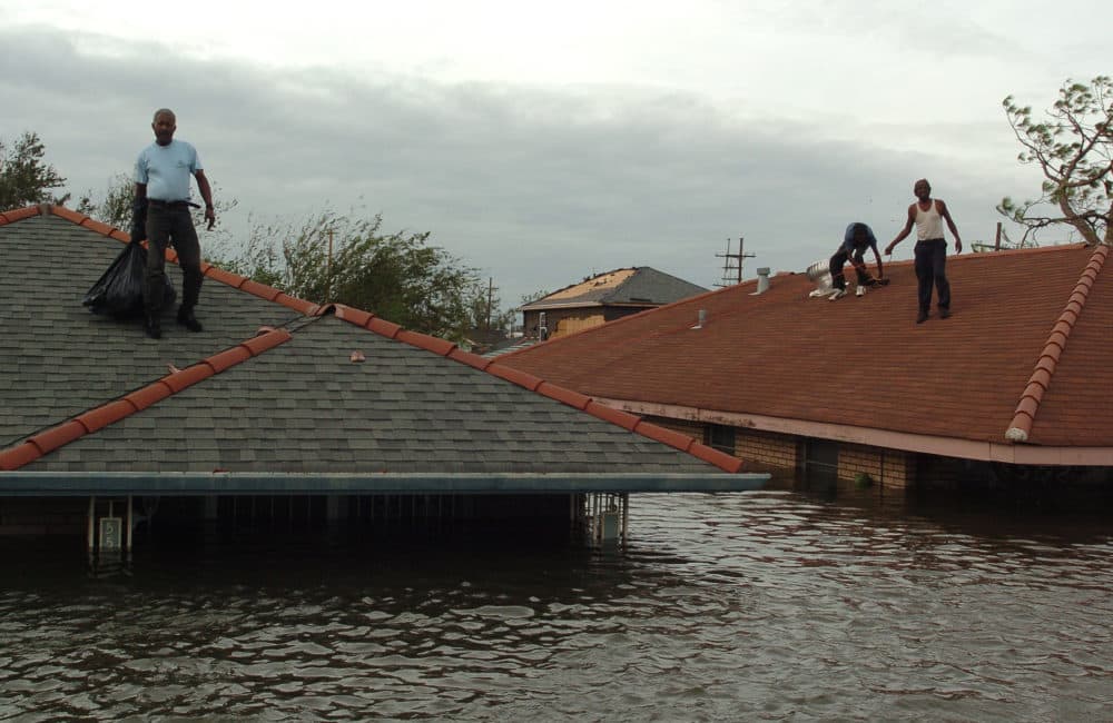Lower Ninth Ward residents stranded on the roofs wait for rescue boats in New Orleans, Louisiana on August 29, 2005, in the wake of Hurricane Katrina. (Marko Georgiev/Getty Images)