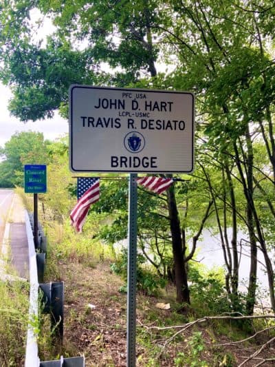 A sign commemorates the naming of a bridge near Bedford, Massachusetts, after Army PFC John Hart and Marine Lance Cpl. Travis Desiato, both of whom died in the Iraq War. (Alex Ashlock/WBUR) 