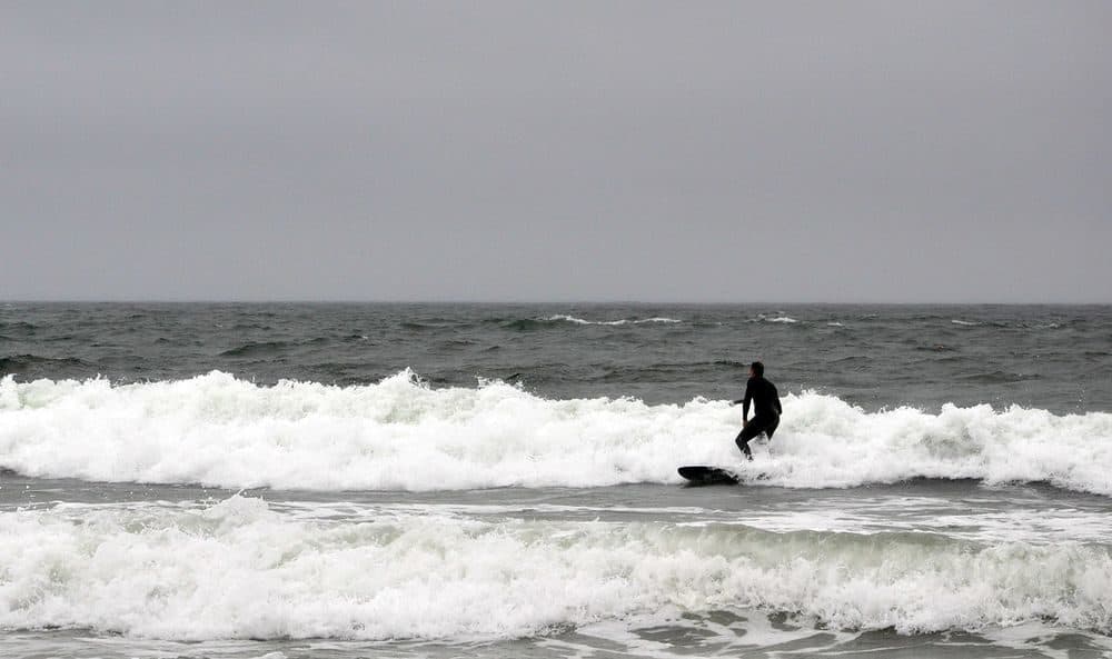 A surfer rides a wave at Narragansett Town Beach on September 2, 2020. (Alex Nunes/The Public's Radio)