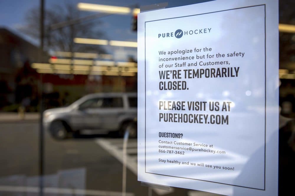 In this May 13, 2020 photo, Pure Hockey announces on its door in Medford that they’re “temporarily closed” and urges customers to visit their website. (Robin Lubbock/WBUR)