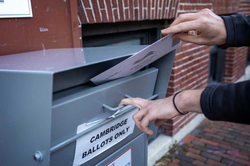On the eve of Election Day in the Massachusetts primary, a voter places his ballot into the Cambridge drop box. (Robin Lubbock/WBUR)